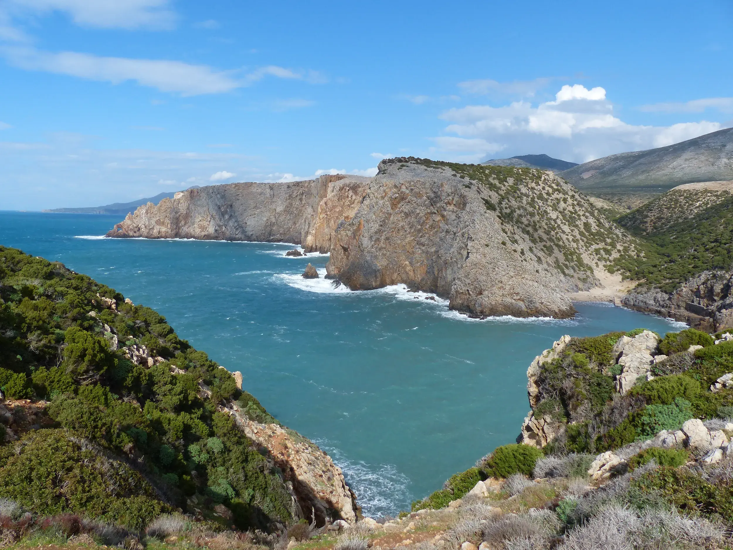 Panoramablick auf die felsige Bucht Canal Grande während einer Küstenwanderung an der wildromantischen Küste Sardiniens.