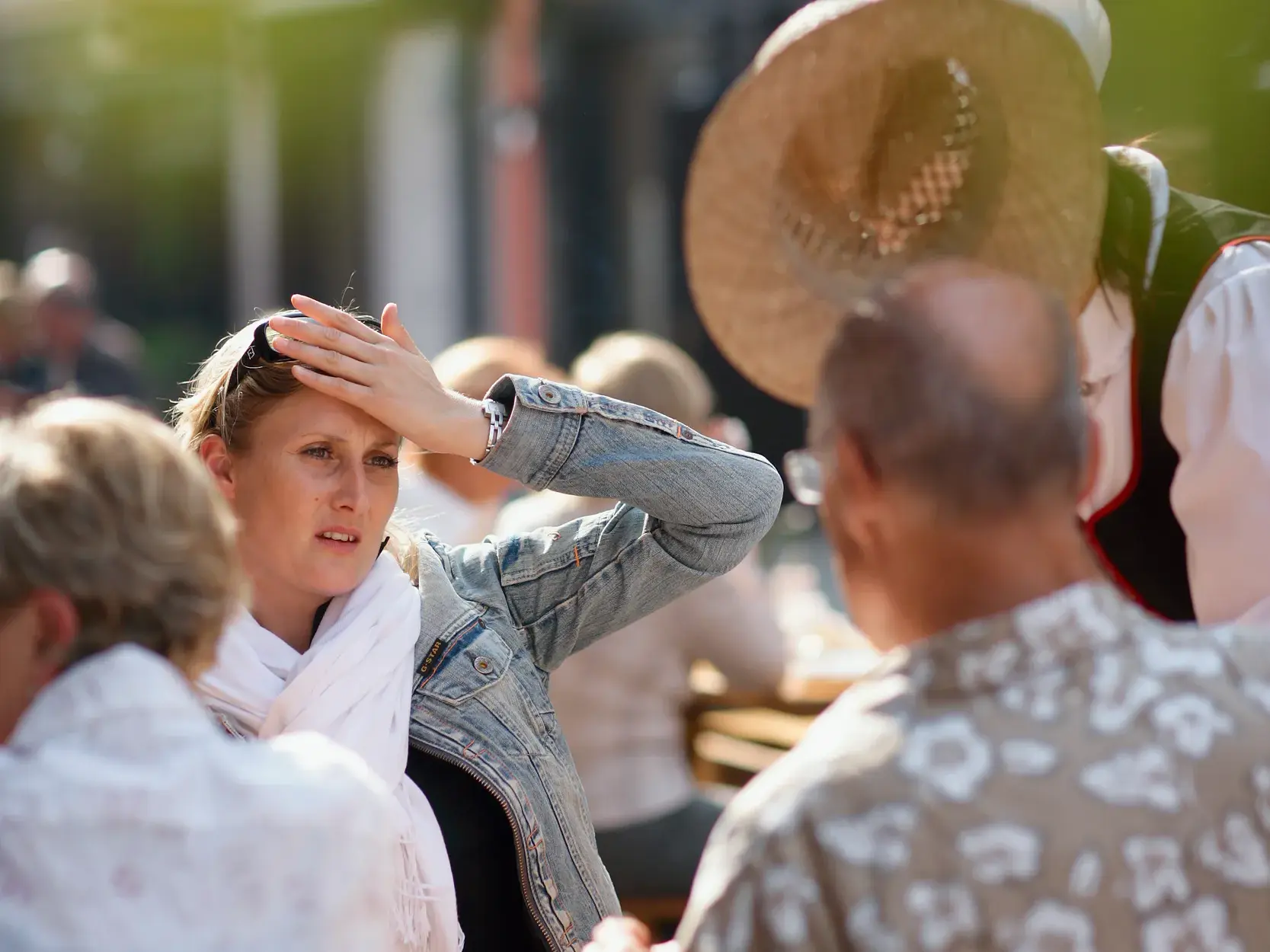 Eine blonde Frau schirmt auf einer Studiosus-Studienreise ihre Augen mit der Hand vor der Sonne ab und blickt konzentriert.