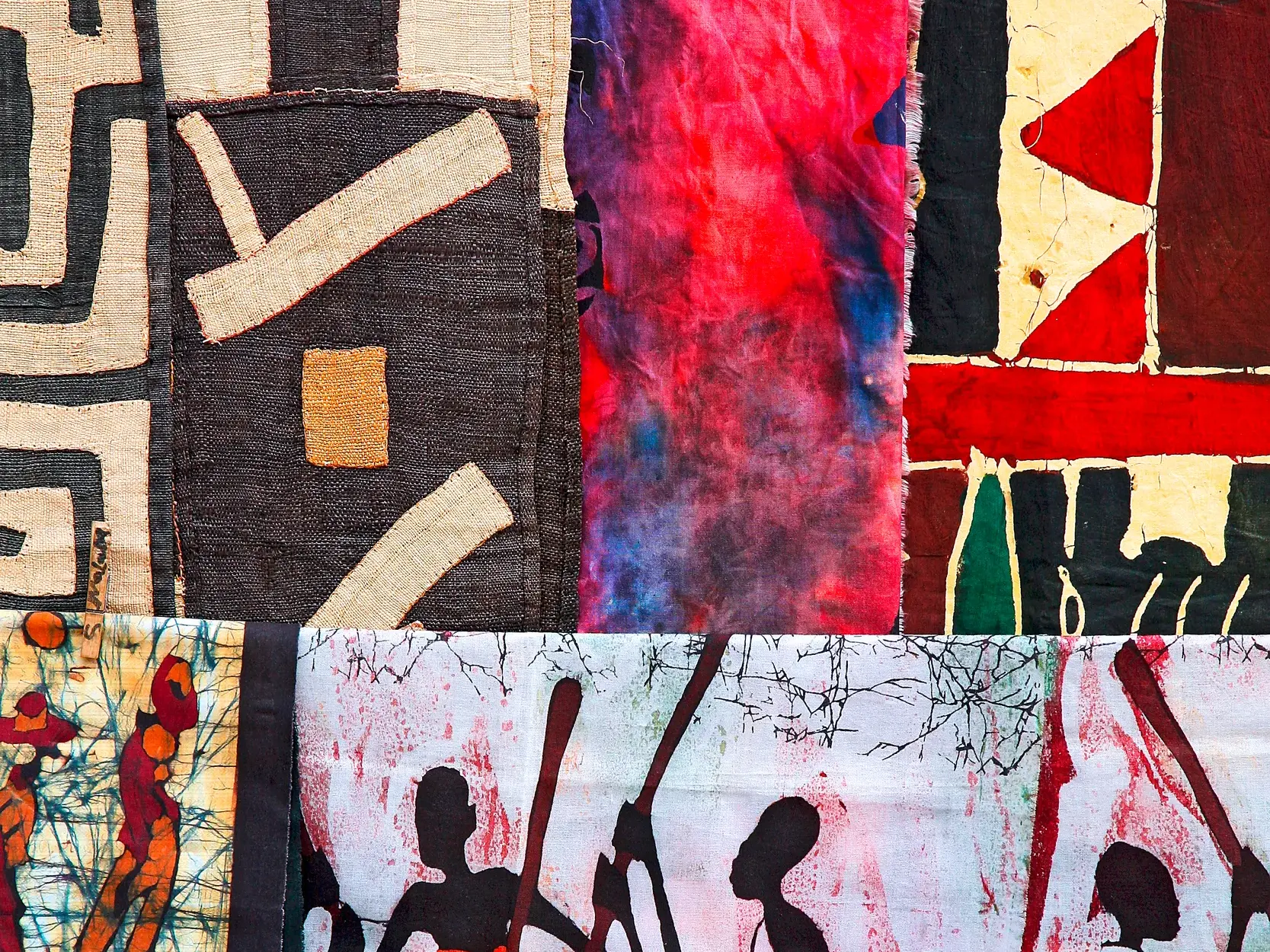 Detailansicht von namibischem Kunsthandwerk: farbenfrohe Textilien mit geometrischen Mustern und Batik-Elementen.