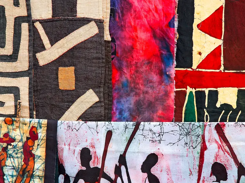 Detailansicht von namibischem Kunsthandwerk: farbenfrohe Textilien mit geometrischen Mustern und Batik-Elementen.