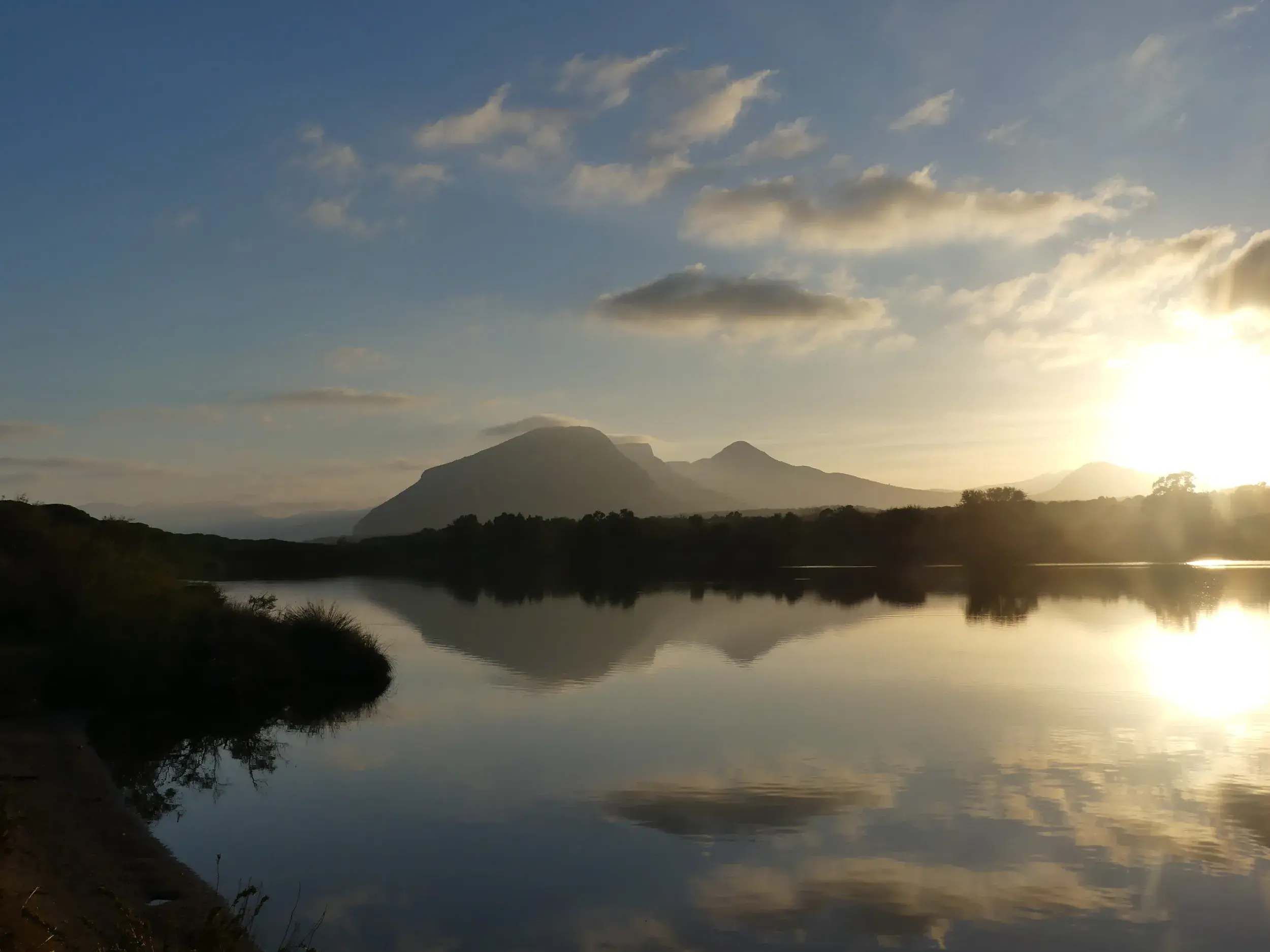 Morgenstimmung auf einer Wanderreise in Sardinien: Die Berge des Supramonte spiegeln sich bei Sonnenaufgang im Wasser.