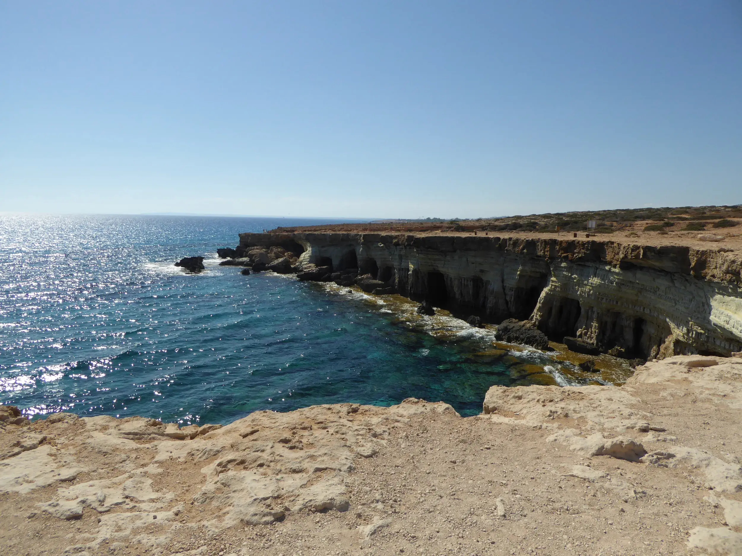 Sonnige Wanderung entlang der Klippen zu den berühmten Meereshöhlen am Kap Greco mit Blick auf das türkise Meer Zyperns.