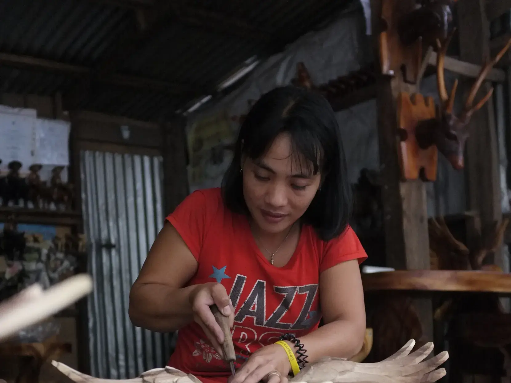 Authentische Begegnung auf den Philippinen: Eine lokale Kunsthandwerkerin bei der filigranen Holzarbeit in ihrer Werkstatt.