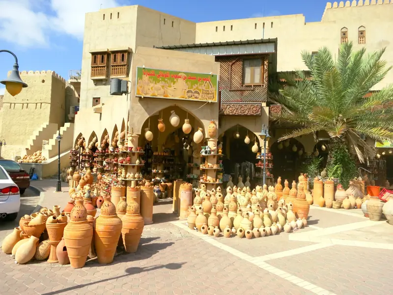 Zahlreiche handgefertigte Töpferwaren vor einem traditionellen Geschäft auf dem Souk in der Oasenstadt Nizwa, Oman.