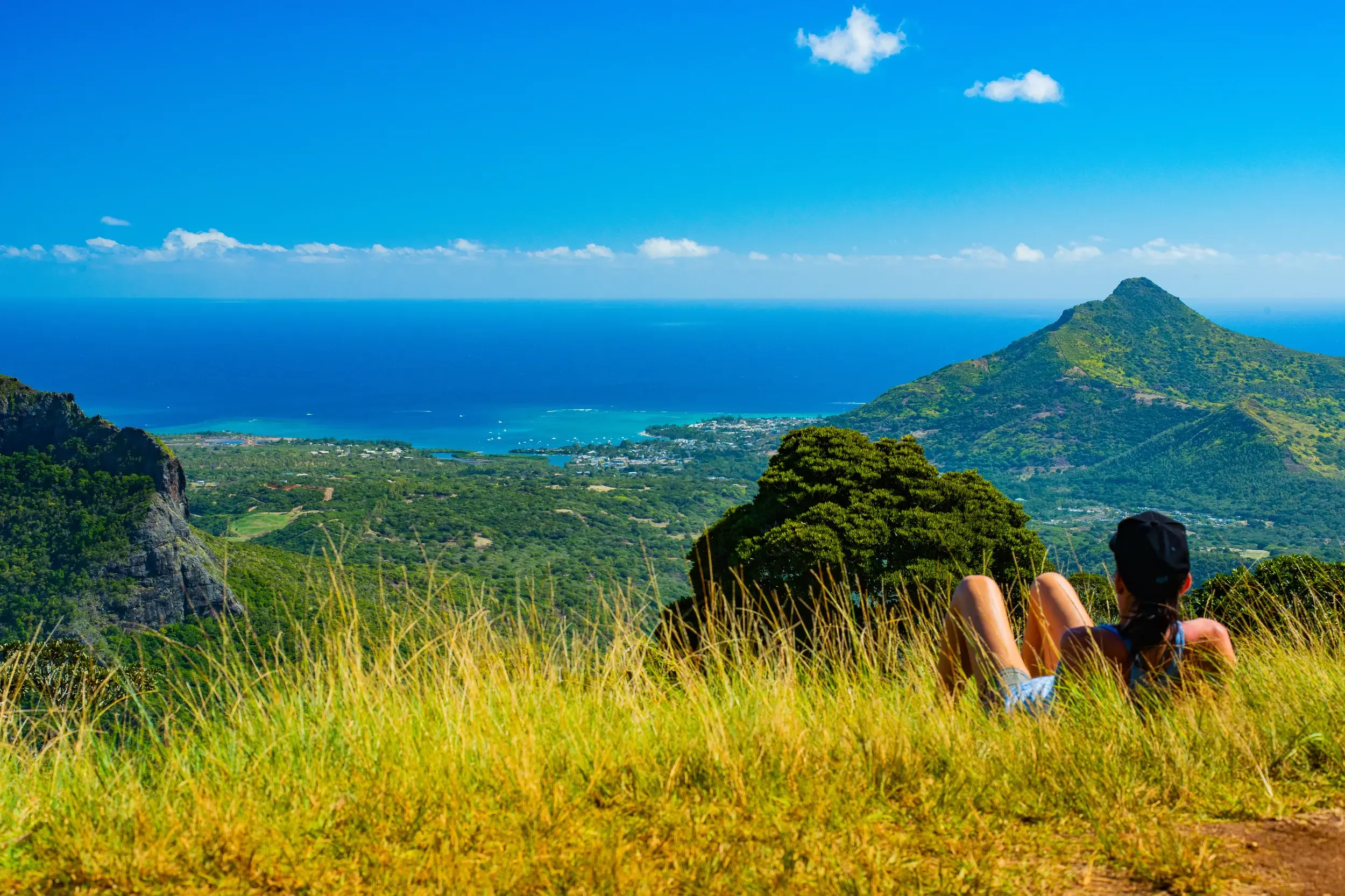 Wanderin bei einer Pause im Black-River-Gorges-Nationalpark mit Panoramablick auf die Küste von Mauritius.