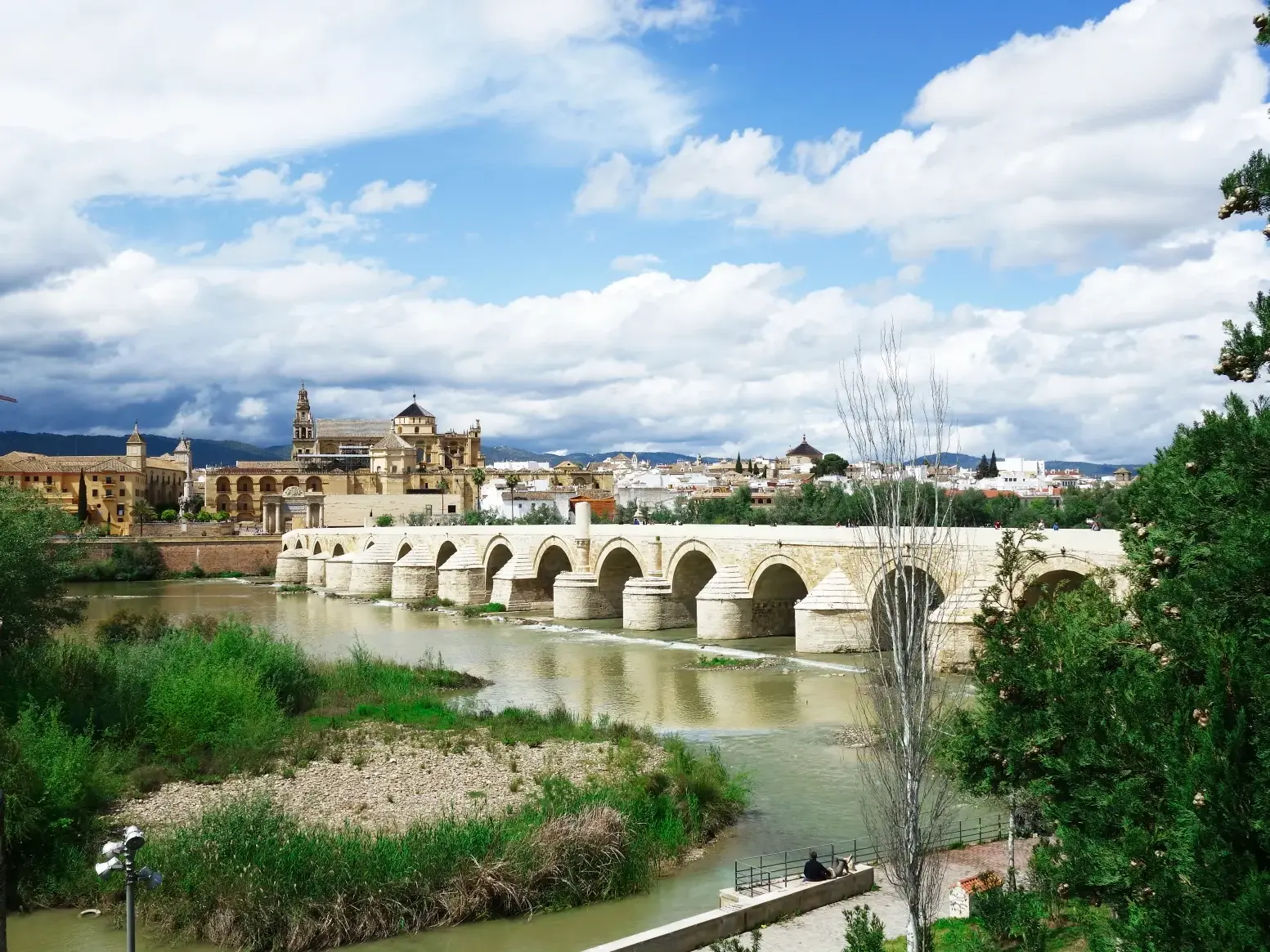 Die historische Römische Brücke spannt sich über den Guadalquivir vor der Skyline von Córdoba mit der Mezquita-Kathedrale.