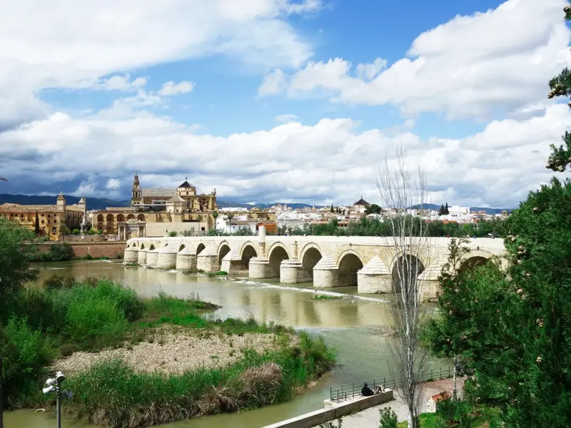 Die historische Römische Brücke spannt sich über den Guadalquivir vor der Skyline von Córdoba mit der Mezquita-Kathedrale.