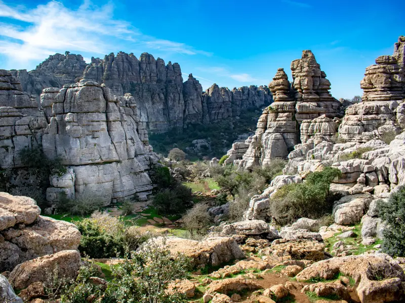 Ein Wanderpfad führt durch die bizarre Karstlandschaft des Naturparks El Torcal in Andalusien mit geschichteten Kalksteinfelsen.