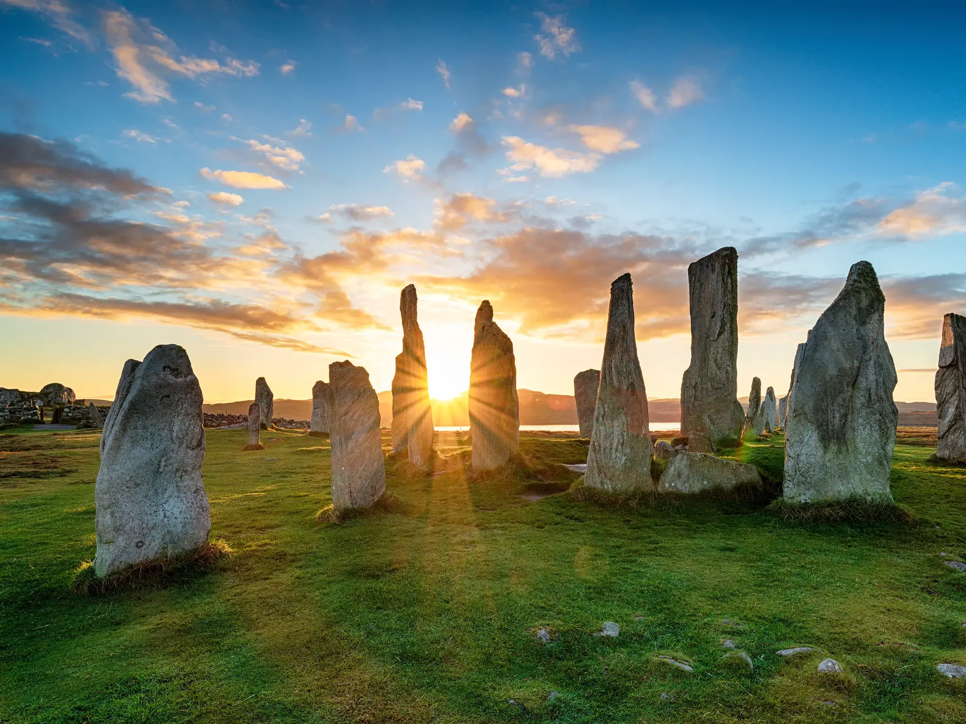 Historische Steinkreise in Callanish auf der Isle of Lewis im warmen Licht der aufgehenden Sonne.