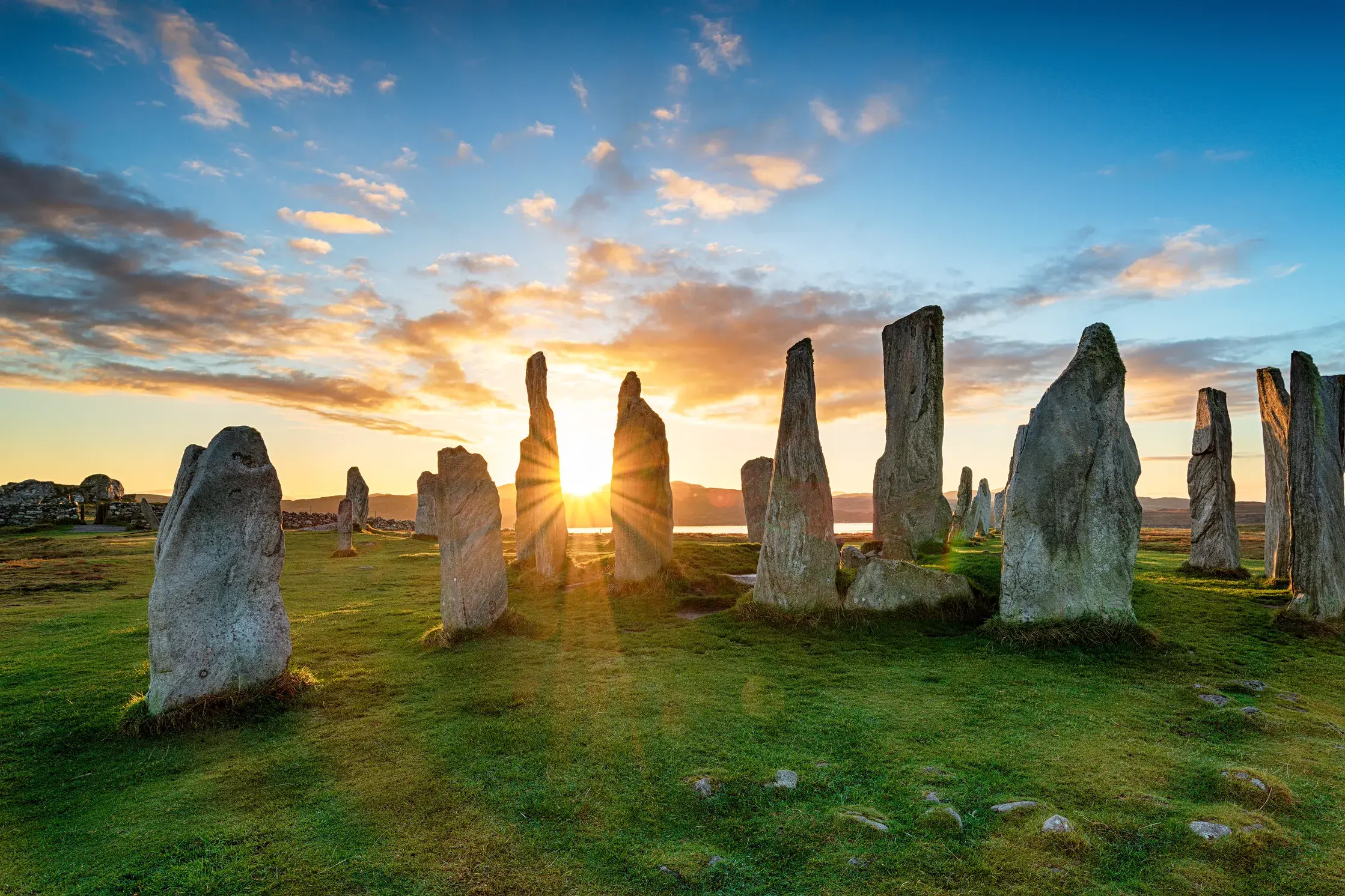 Historische Steinkreise in Callanish auf der Isle of Lewis im warmen Licht der aufgehenden Sonne.