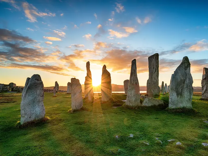 Historische Steinkreise in Callanish auf der Isle of Lewis im warmen Licht der aufgehenden Sonne.