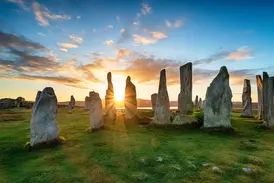 Historische Steinkreise in Callanish auf der Isle of Lewis im warmen Licht der aufgehenden Sonne.