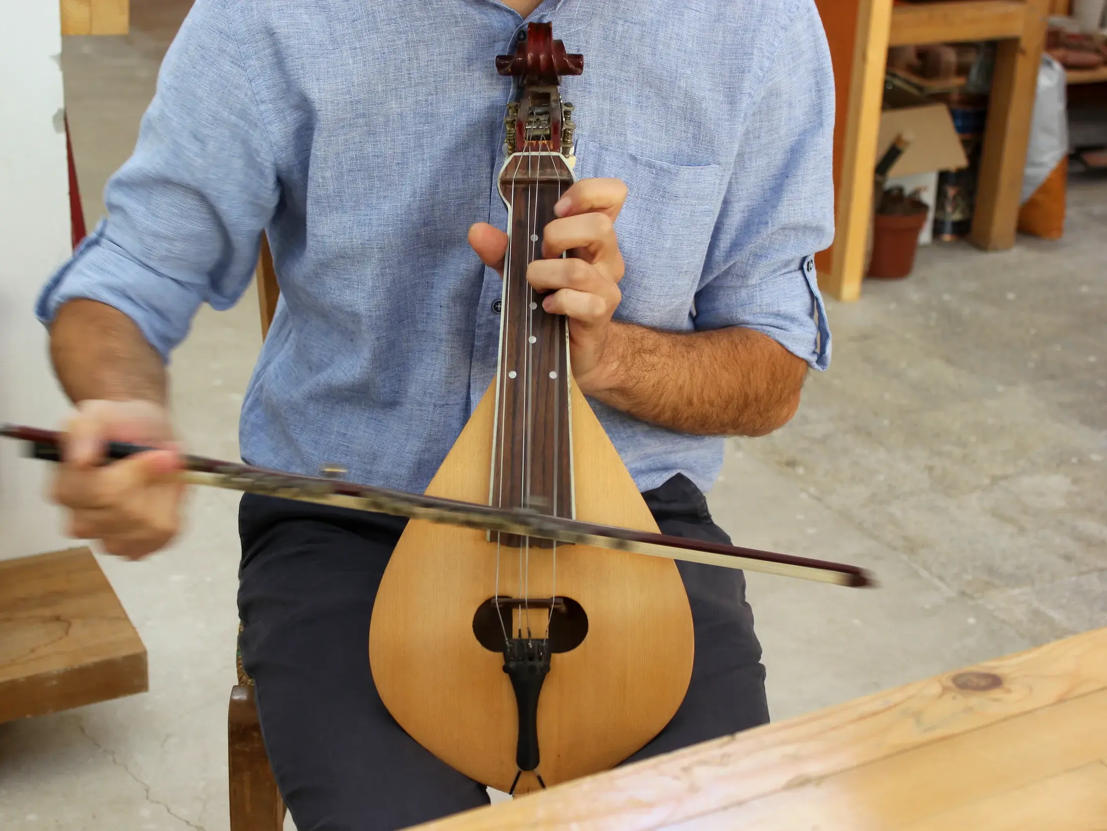 Authentische Begegnung auf einer Griechenland-Reise: Ein Musiker spielt mit einem Bogen eine traditionelle Lyra.