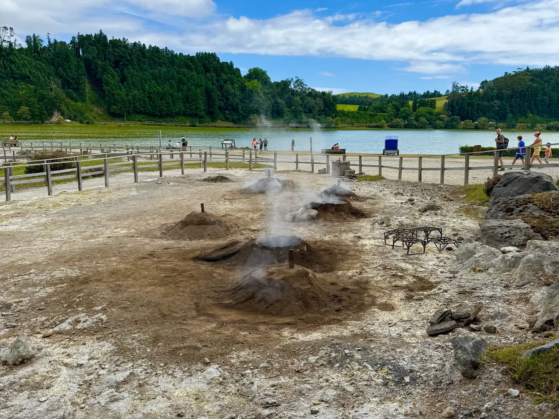 Aus Erdhügeln aufsteigender Dampf der Kochstellen für Cozido in Furnas am Seeufer auf der Azoreninsel Sao Miguel.