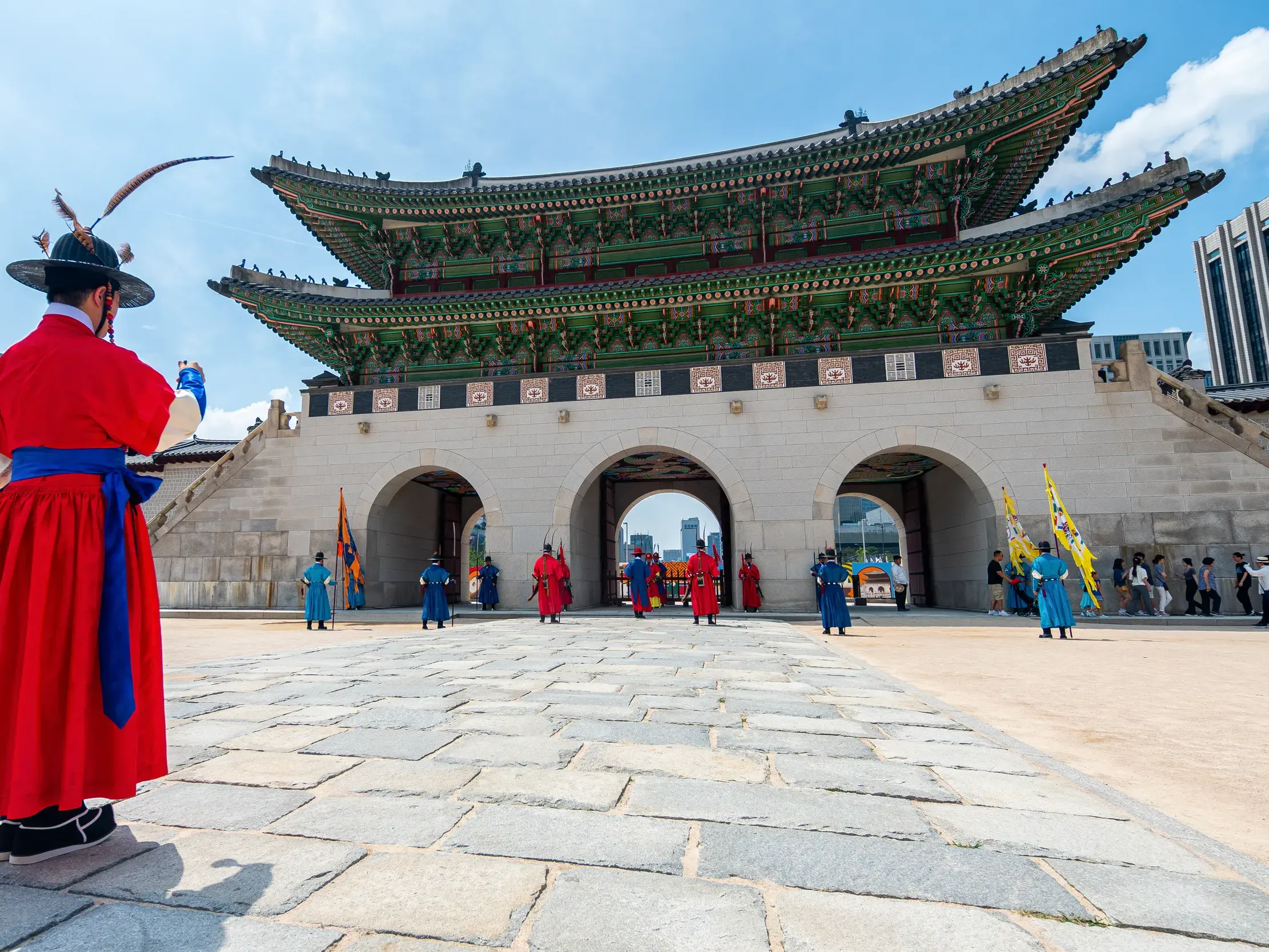 Wache in roter Uniform blickt auf die zeremonielle Wachablösung vor dem prächtigen Gyeongbok-Palast in Seoul.
