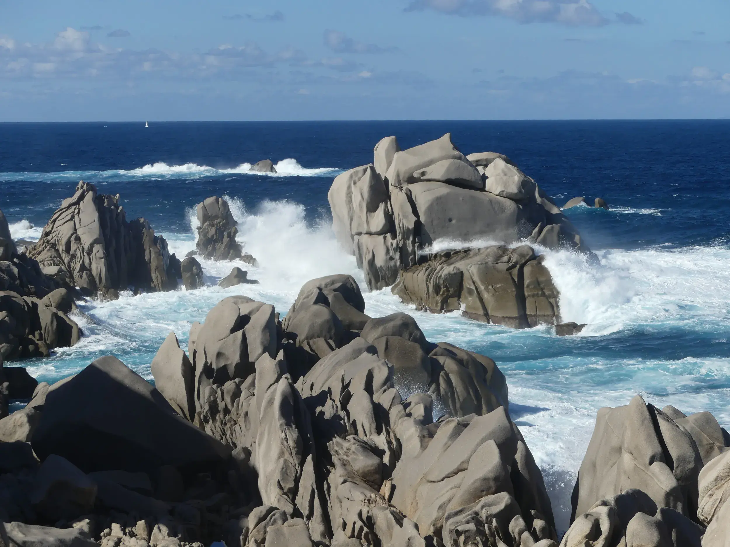 Wilde Brandung mit Gischt an den bizarr geformten Granitfelsen am Capo Testa, dem nördlichsten Punkt von Sardinien.
