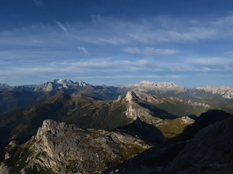 Weitblick über die schroffen Gipfel und grünen Täler der Dolomiten während einer Hüttenwanderung auf dem Höhenweg Alta Via 1.