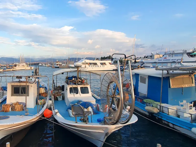 Fischerboote und Yachten liegen im Hafen von Limassol auf Zypern unter einem bewölkten blauen Himmel am späten Nachmittag.
