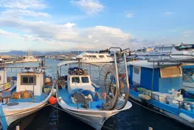 Fischerboote und Yachten liegen im Hafen von Limassol auf Zypern unter einem bewölkten blauen Himmel am späten Nachmittag.