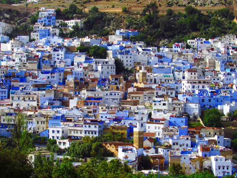 Panorama der blau-weißen Medina von Chefchaouen, malerisch gelegen am Hang des Rif-Gebirges auf einer Wanderreise.