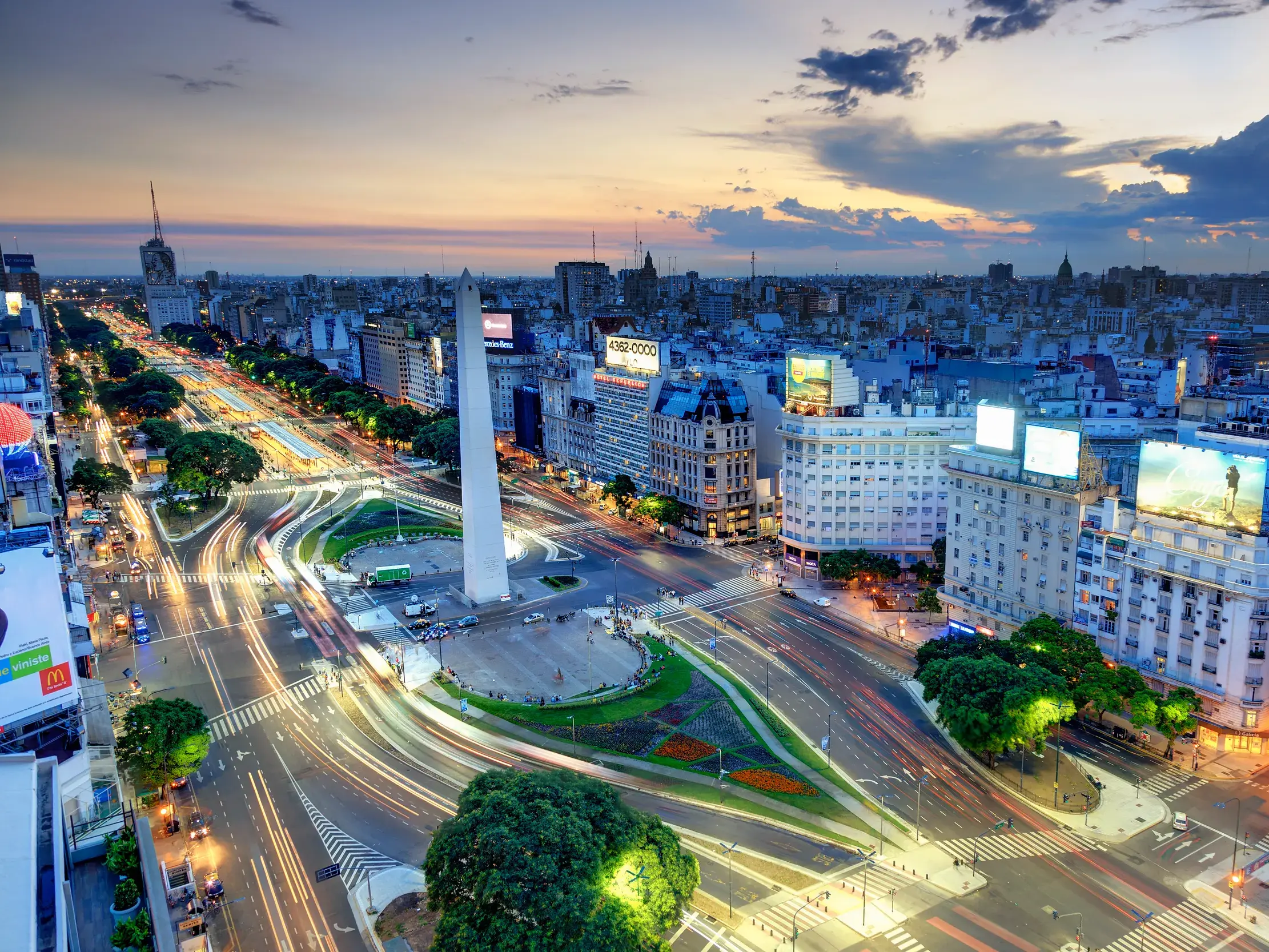 Abenddämmerung über Buenos Aires mit Blick auf den Obelisken an der belebten Avenida 9 de Julio mit langen Lichtstreifen.