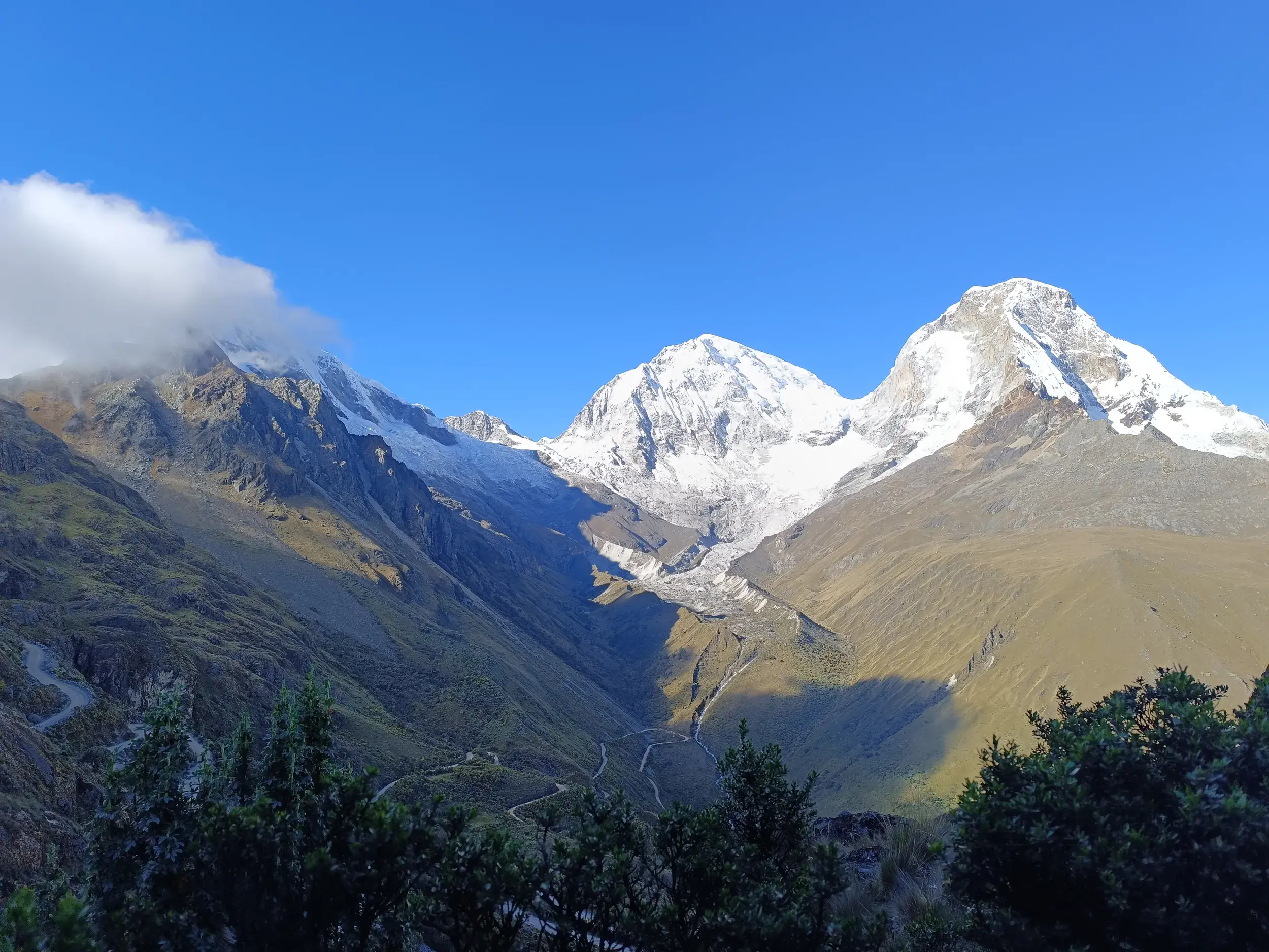 Majestätische, schneebedeckte Gipfel des Huascarán in der peruanischen Cordillera Blanca unter strahlend blauem Himmel.