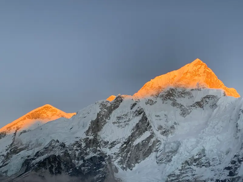 Die schneebedeckten Gipfel von Nuptse und Mt. Everest leuchten im goldenen Licht des Sonnenaufgangs in der Khumbu-Region.