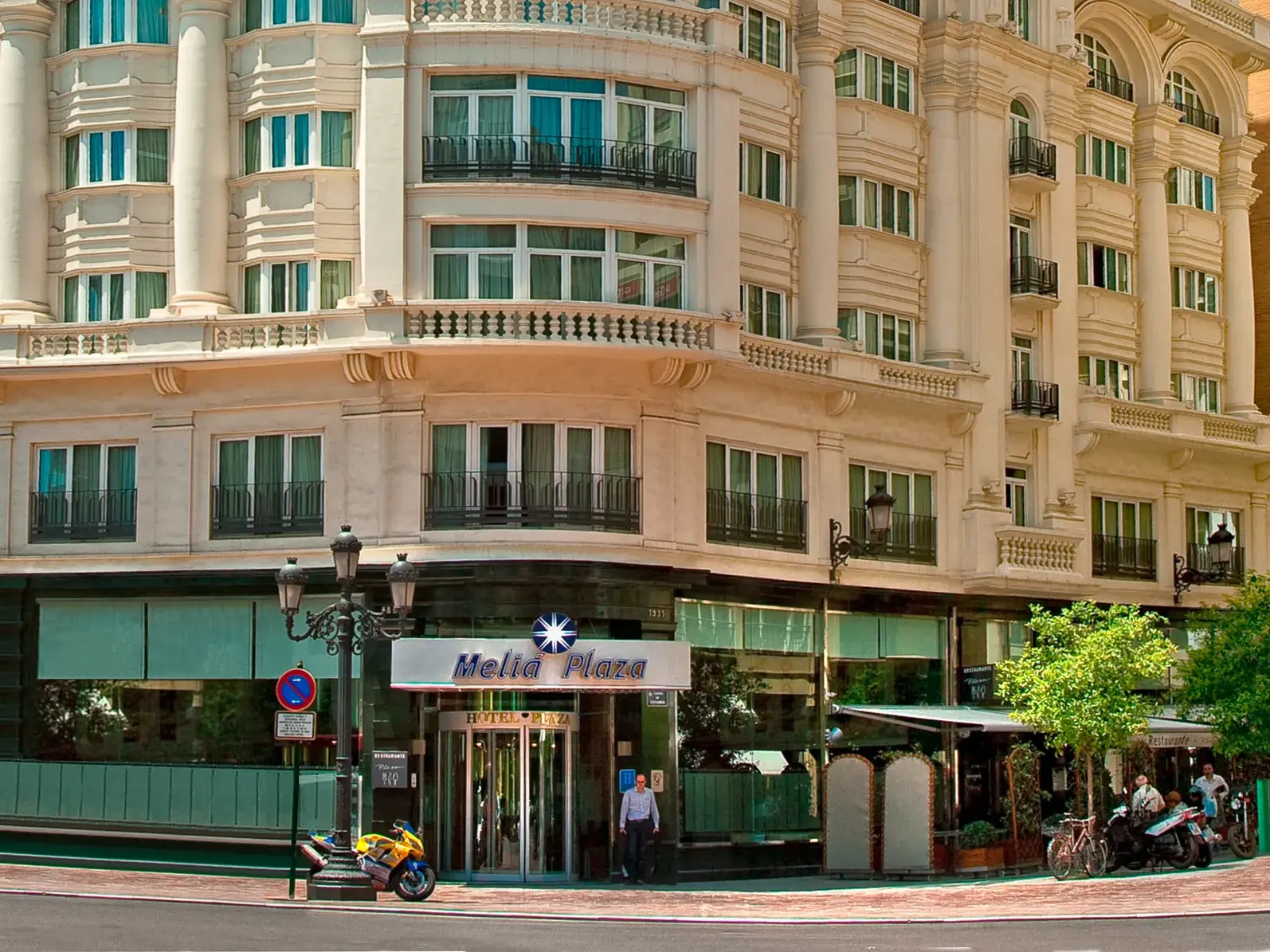 Die helle, klassische Fassade des zentral gelegenen Hotel Meliá Plaza in Valencia an einer belebten Straßenecke.