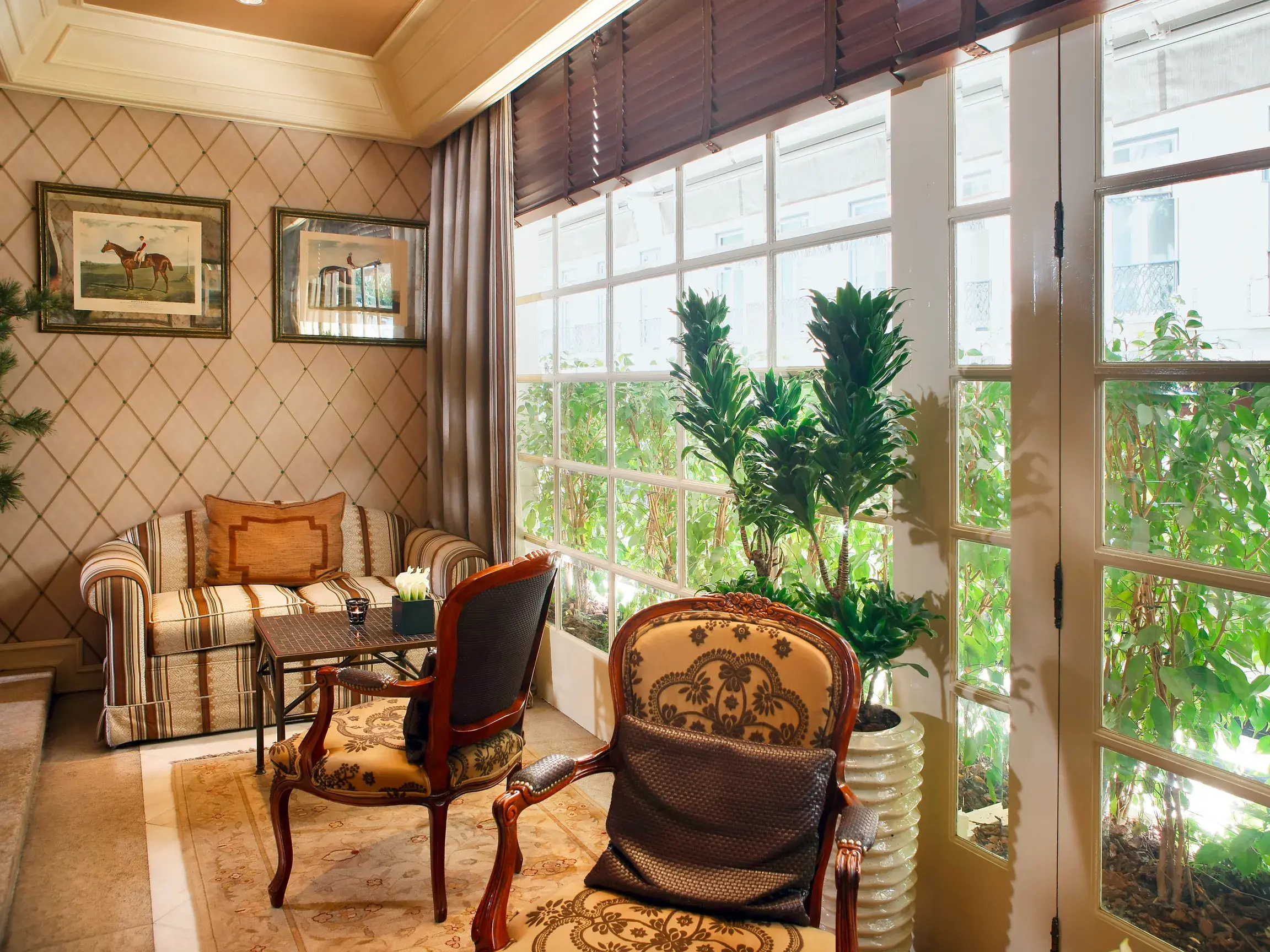 Einladende, klassische Lounge im Hotel Lisboa Plaza in Lissabon mit Sesseln und Sofa vor einer großen Fensterfront.