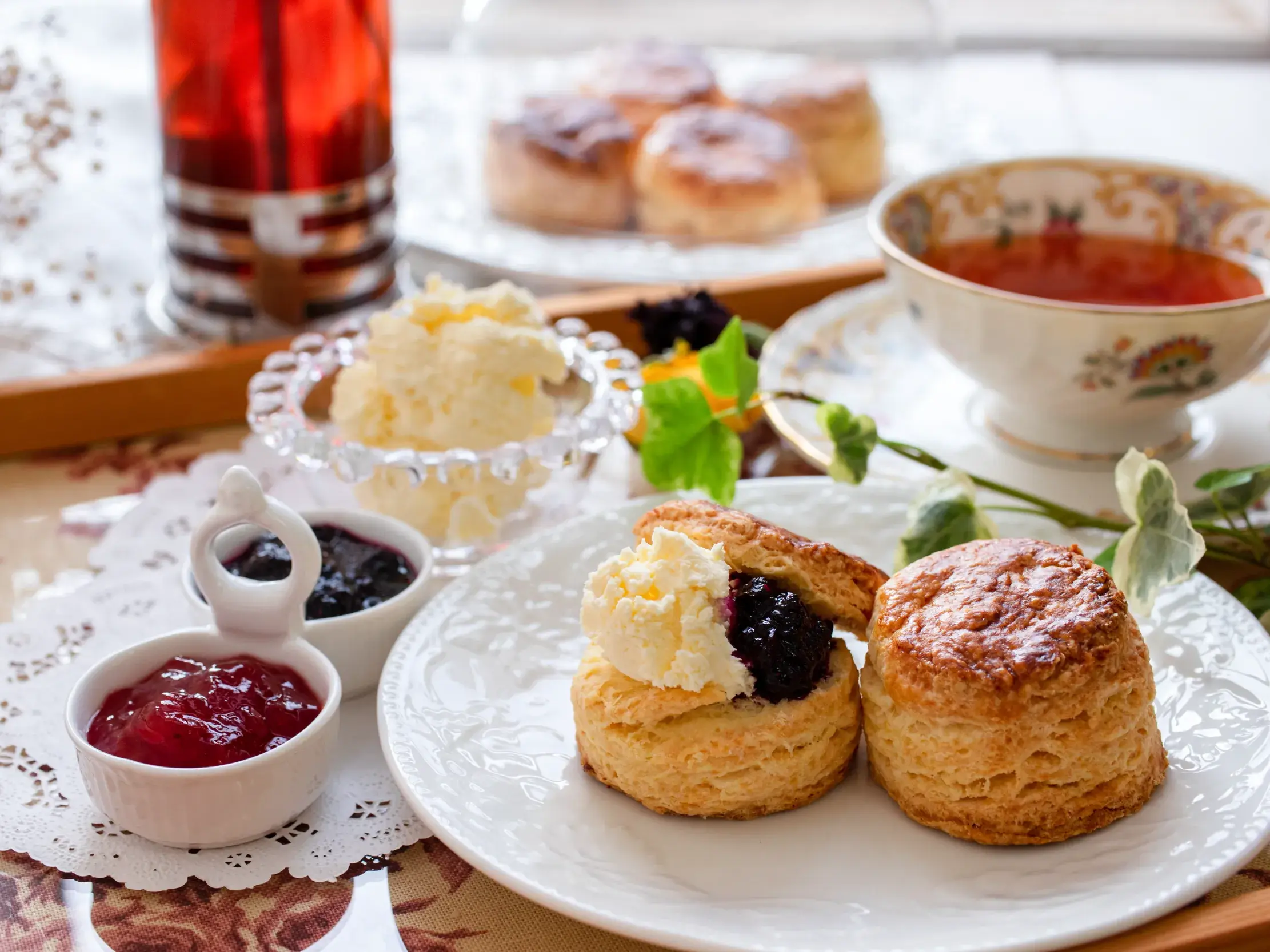 Traditioneller britischer Cream Tea mit frischen Scones, Clotted Cream und Marmelade, serviert auf einem Tablett in Südengland.
