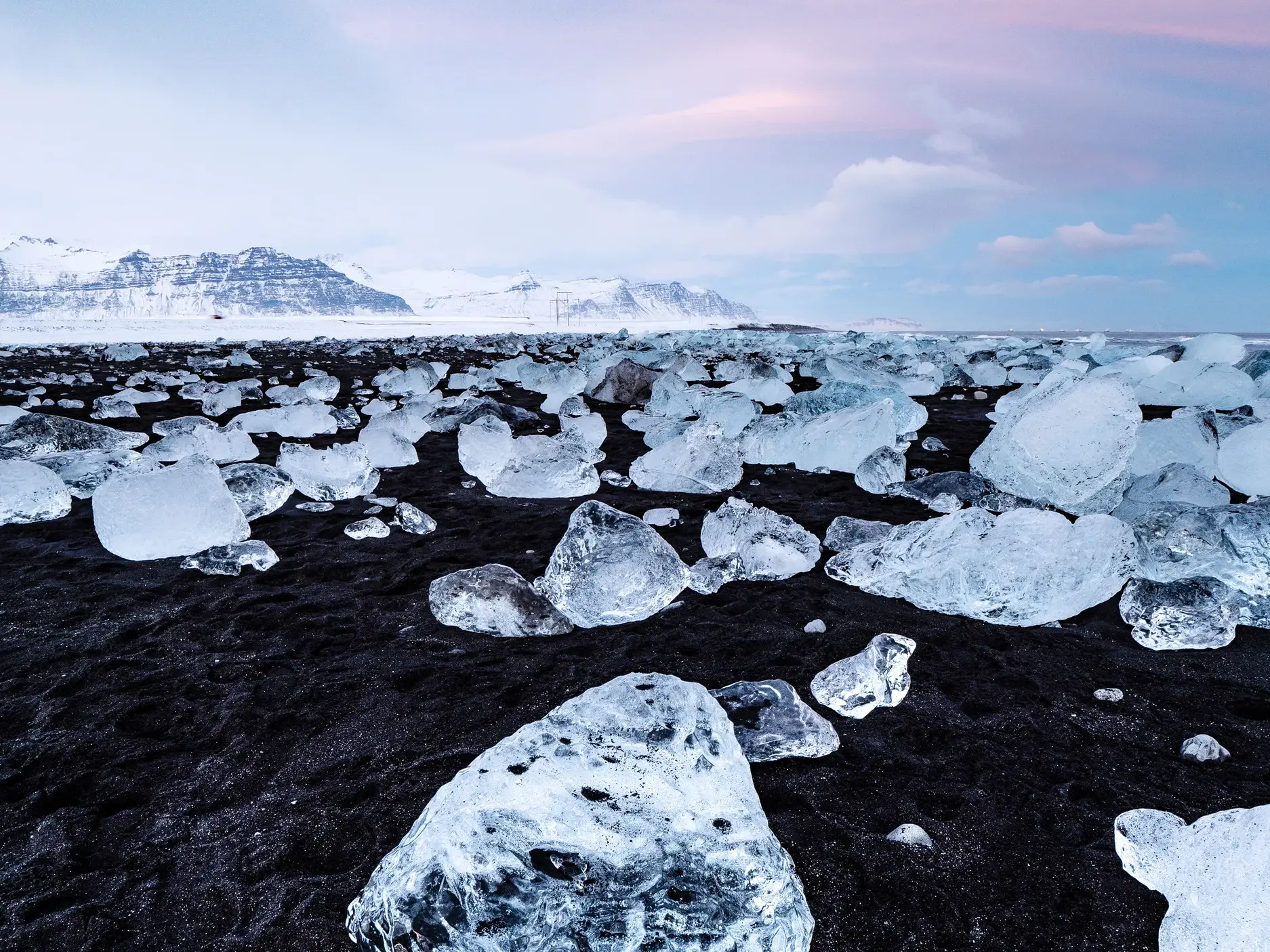 Glitzernde Eisblöcke von der Jökulsárlón-Gletscherlagune auf dem schwarzen Vulkansand des Diamond Beach in Island.