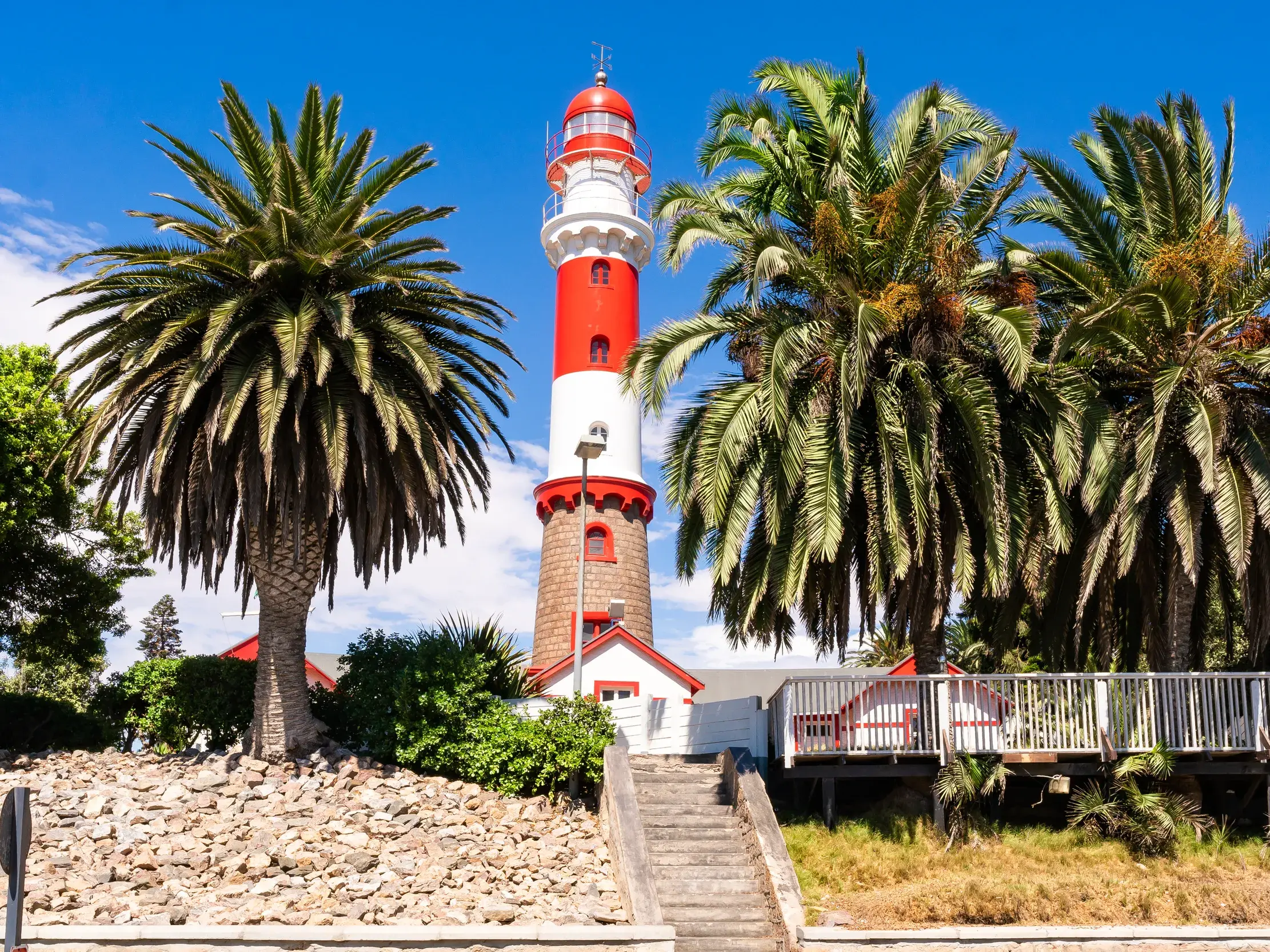 Während der Studiosus-Gruppenreise sehen Sie den markanten, rot-weißen Leuchtturm von Swakopmund in Namibia, ein Wahrzeichen der Kolonialzeit.