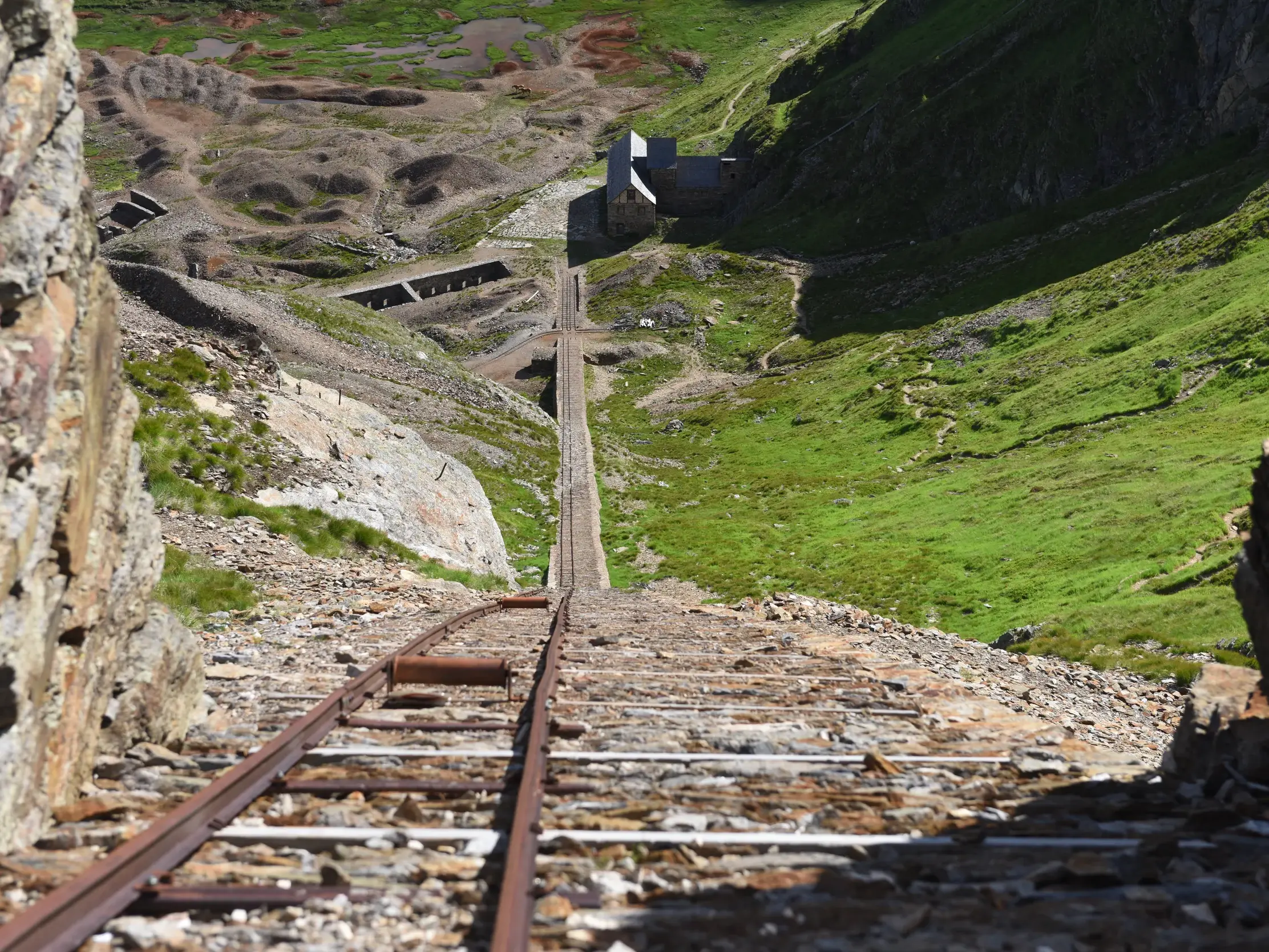 Blick über historische Gleise eines steilen Bremsbergs am Schneeberg auf das ehemalige Bergbaugebiet in den Stubaier Alpen.