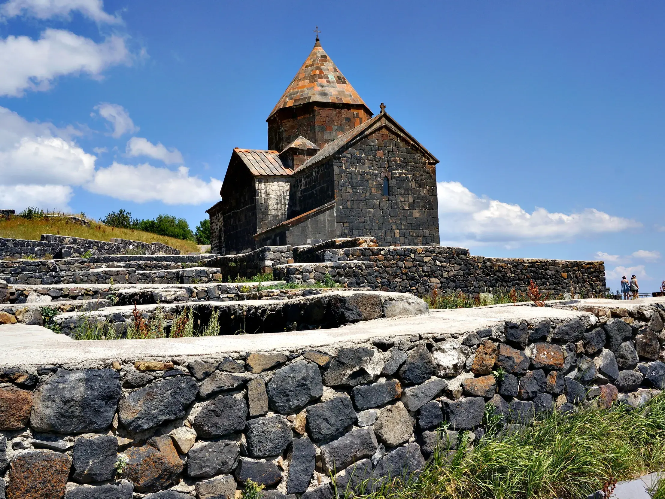 Das historische Kloster Sewanawank aus dunklem Stein thront über alten Fundamenten am Ufer des Sewansees in Armenien.