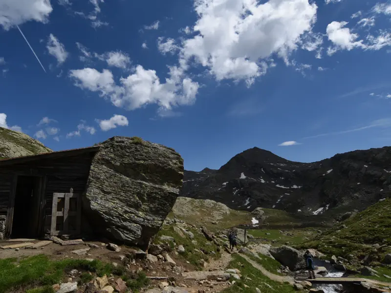 Urige Almhütte auf dem Weg zur Bockerhütte nahe den Spronser Seen, mit Wanderern im alpinen Gelände der Texelgruppe.