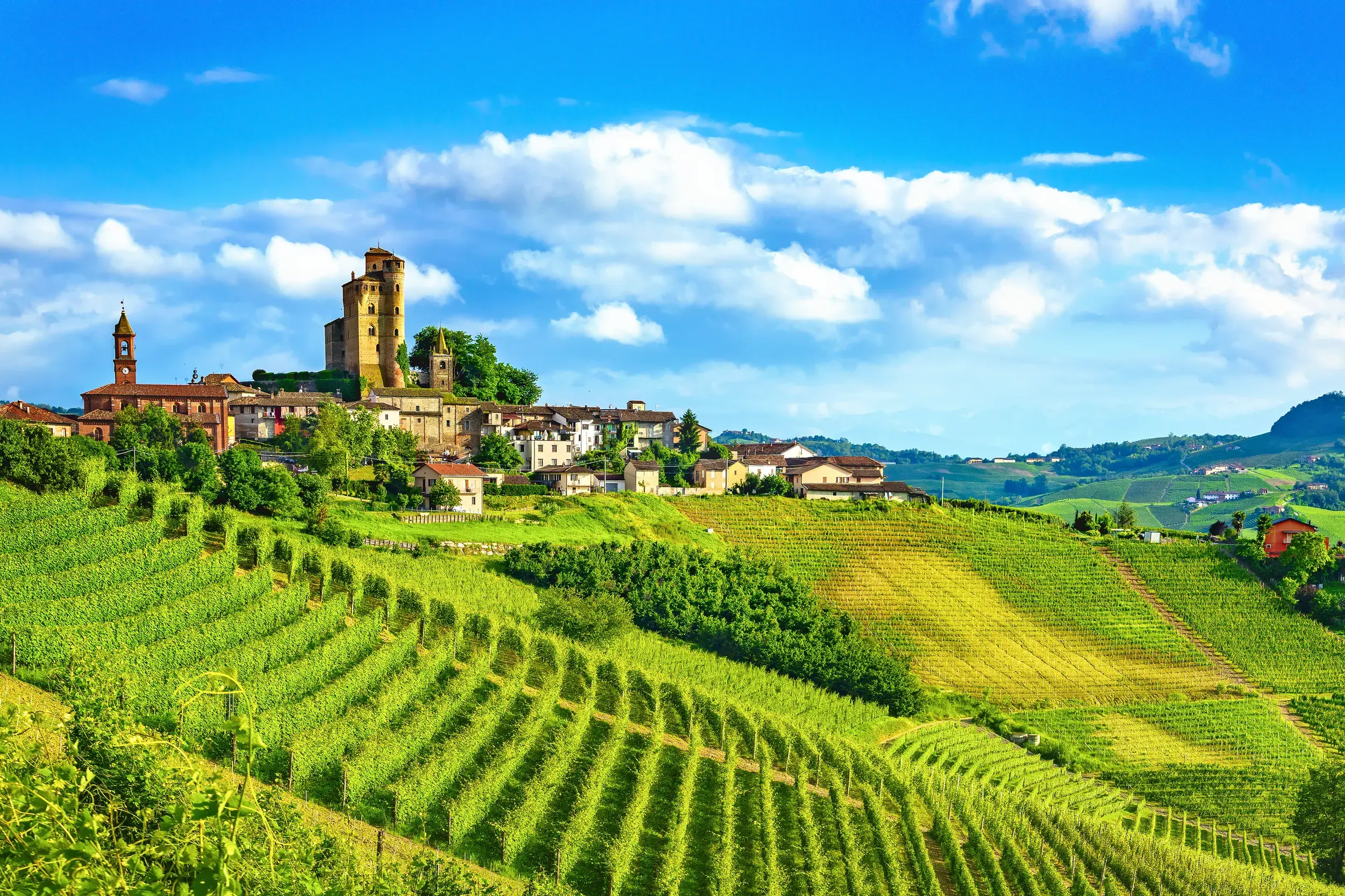 Das Castello di Serralunga d'Alba thront über einem Dorf inmitten der grünen, sonnigen Weinberge der Langhe im Piemont.