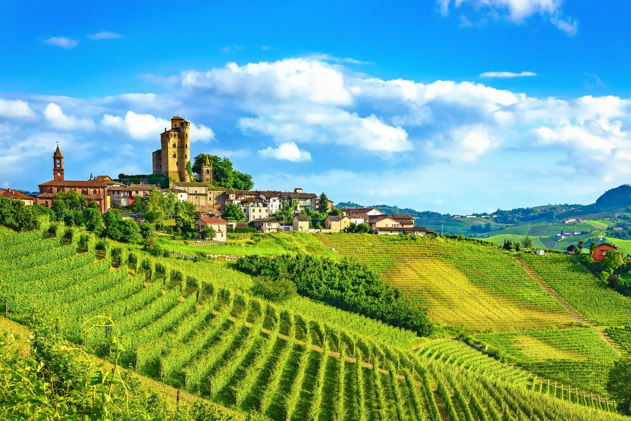 Das Castello di Serralunga d'Alba thront über einem Dorf inmitten der grünen, sonnigen Weinberge der Langhe im Piemont.