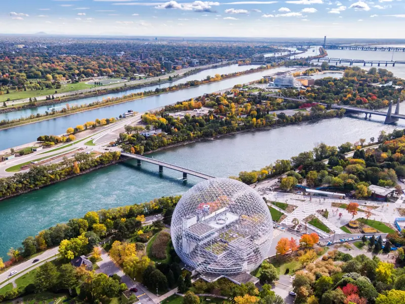 Vogelperspektive auf die Biosphäre in Montreal, umgeben vom Sankt-Lorenz-Strom mit buntem Herbstlaub am Ende der Radreise.