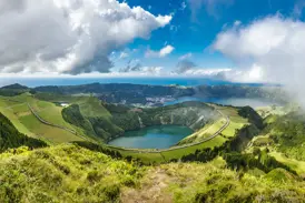 Weitblick von einem Wanderweg auf die grünen Kraterhänge und Seen der Caldeira de Sete Cidades auf der Azoreninsel São Miguel.