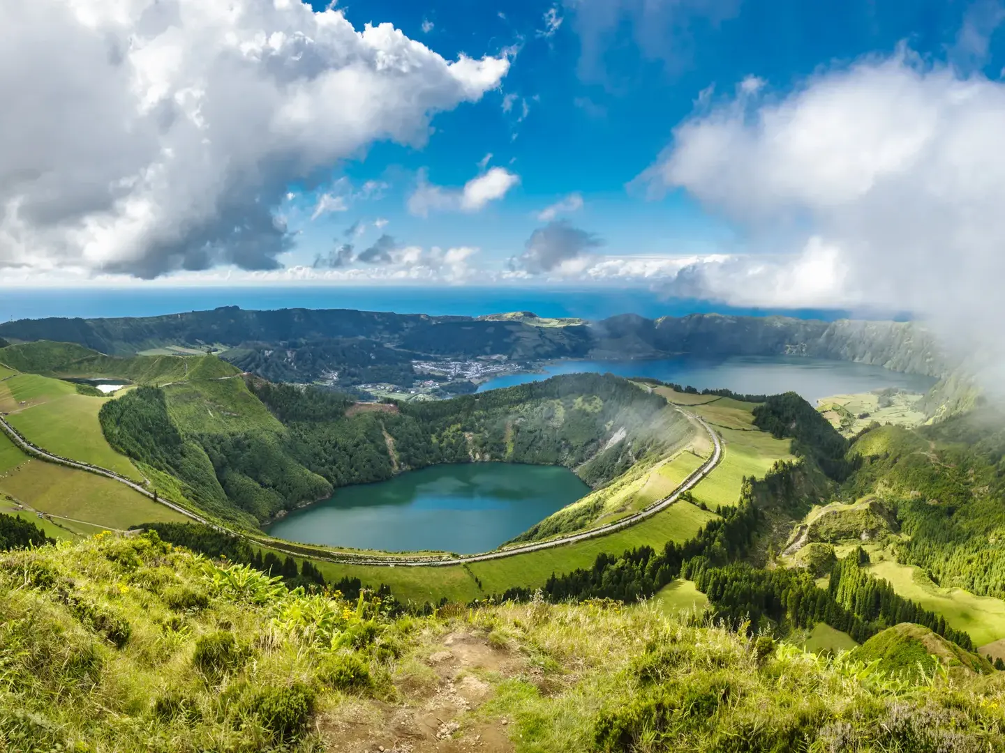 Weite Aussicht von einem Wanderpfad auf die Vulkankrater und Seen der Caldeira da Sete Cidades auf der Insel São Miguel.