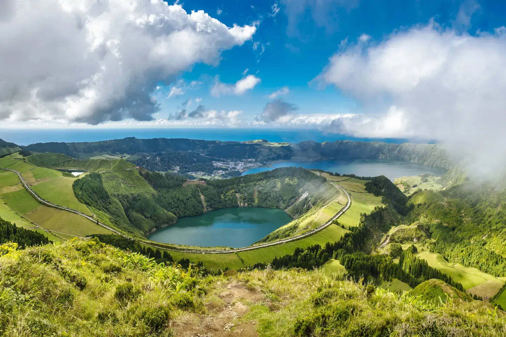 Weite Aussicht von einem Wanderpfad auf die Vulkankrater und Seen der Caldeira da Sete Cidades auf der Insel São Miguel.