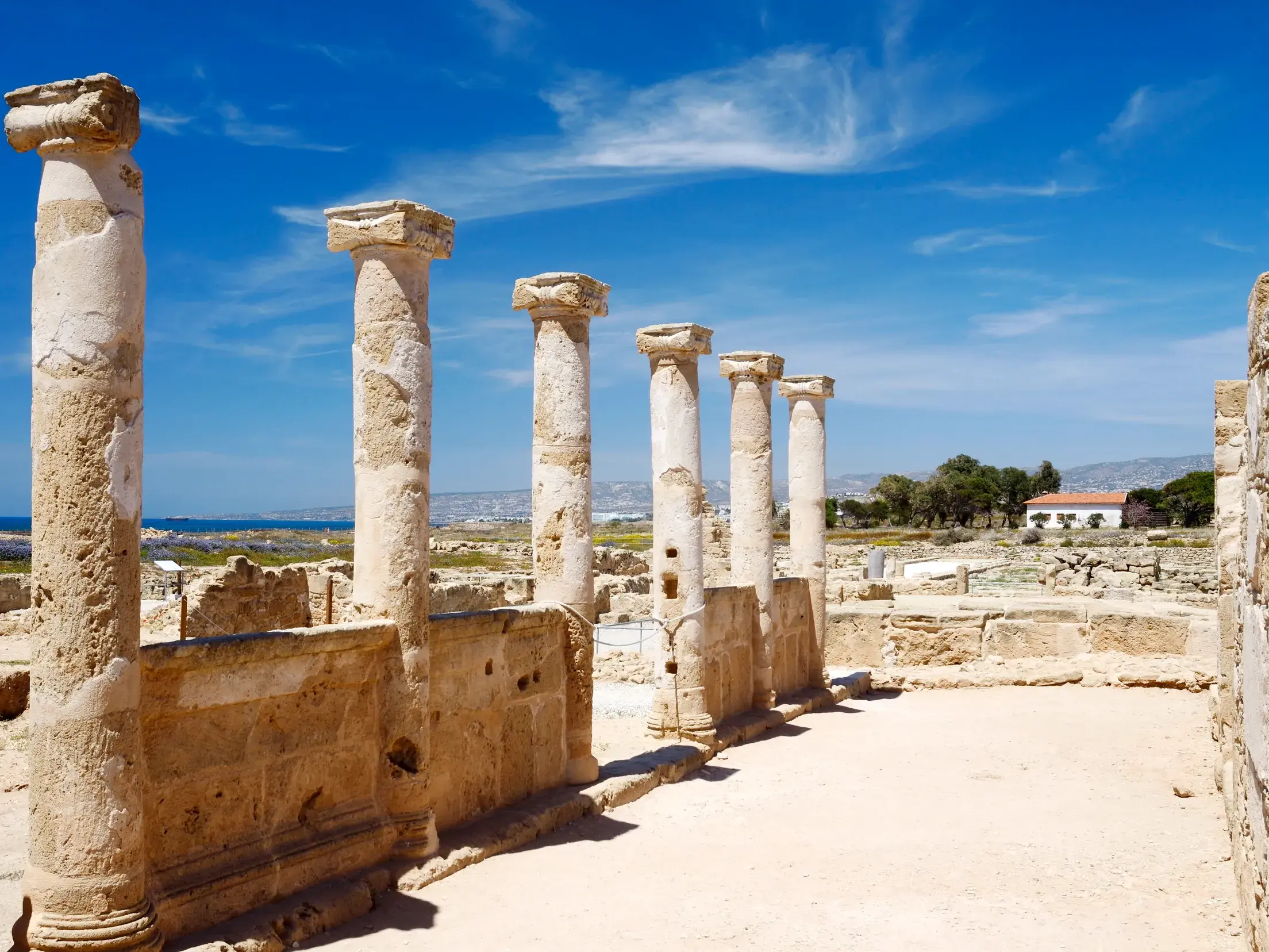 Antike Säulen im UNESCO-Welterbe Archäologischer Park Paphos mit Blick auf das Meer bei sonnigem Wetter auf Zypern.