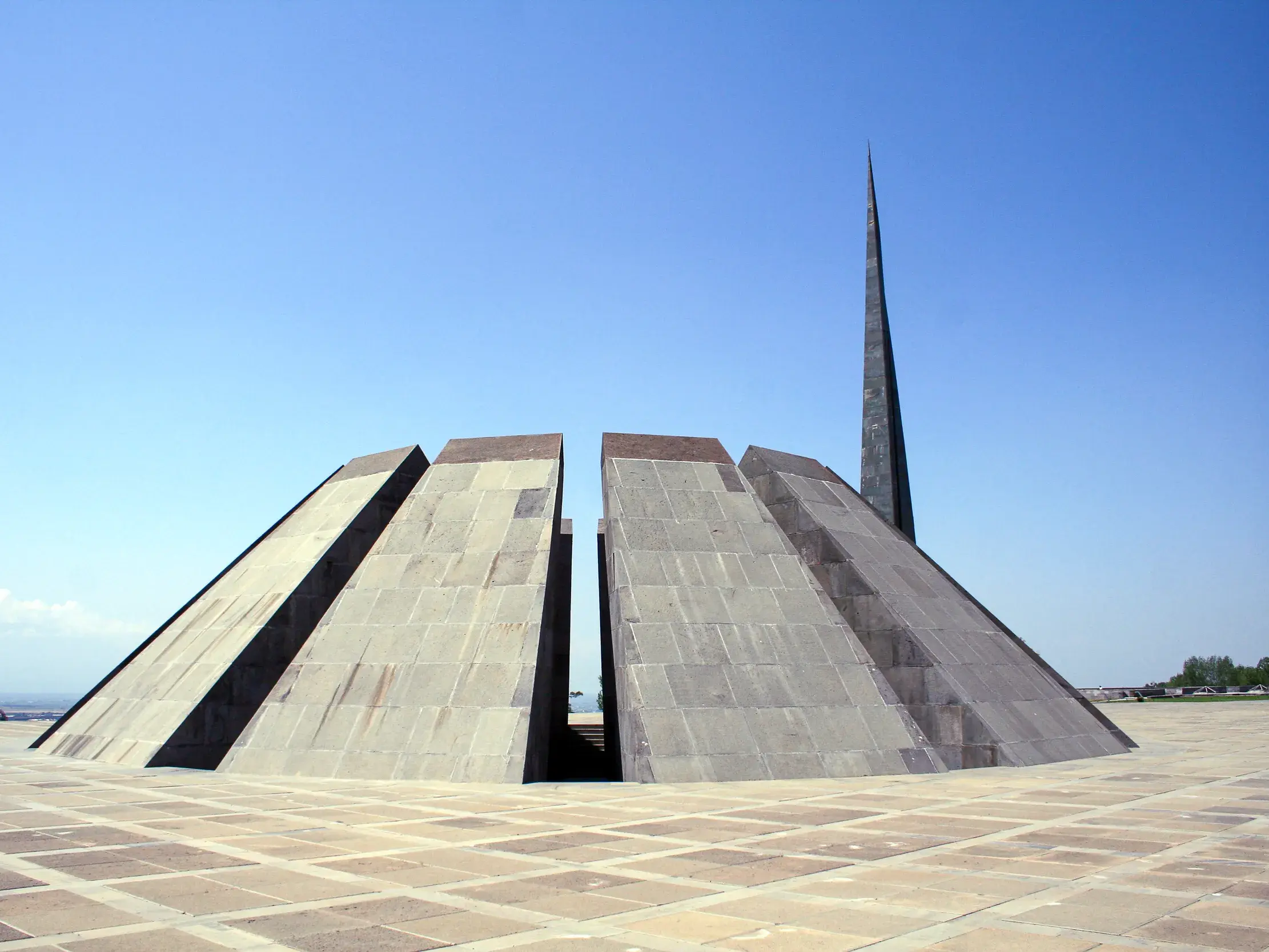 Das armenische Genozid-Mahnmal in Eriwan mit seinen zwölf Basaltstelen unter strahlend blauem Himmel.