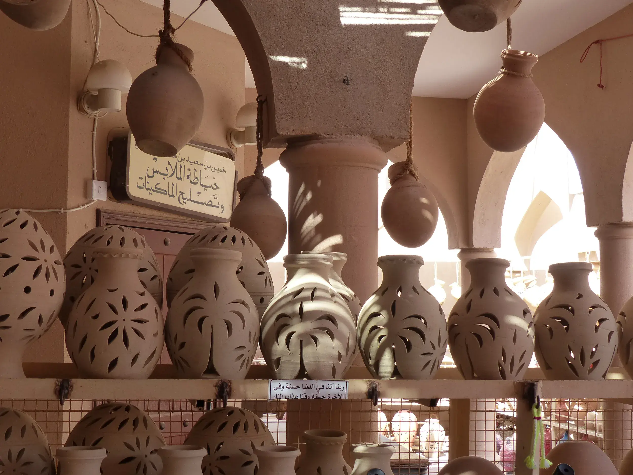 Handgefertigte Töpfervasen mit filigranen Mustern auf Regalen im für seine Töpferkunst bekannten Ort Bahla im Oman.