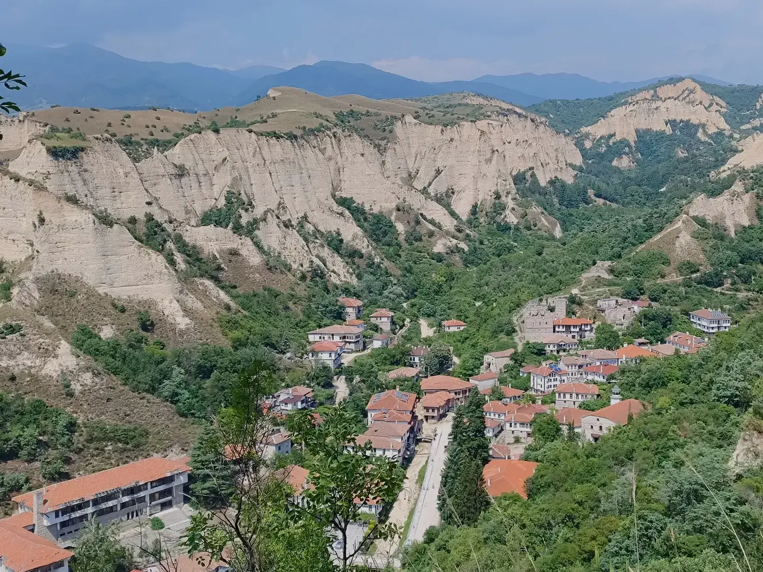 Panoramablick auf die Stadt Melnik in Bulgarien, eingebettet in einem grünen Tal zwischen den beeindruckenden Sandpyramiden.
