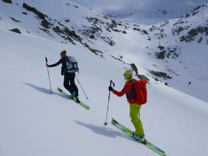 Zwei Skitourengeher auf dem Aufstieg durch die weite, unberührte Schneelandschaft der einsamen Berge im Balkan.