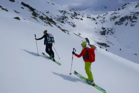 Zwei Skitourengeher auf dem Aufstieg durch die weite, unberührte Schneelandschaft der einsamen Berge im Balkan.