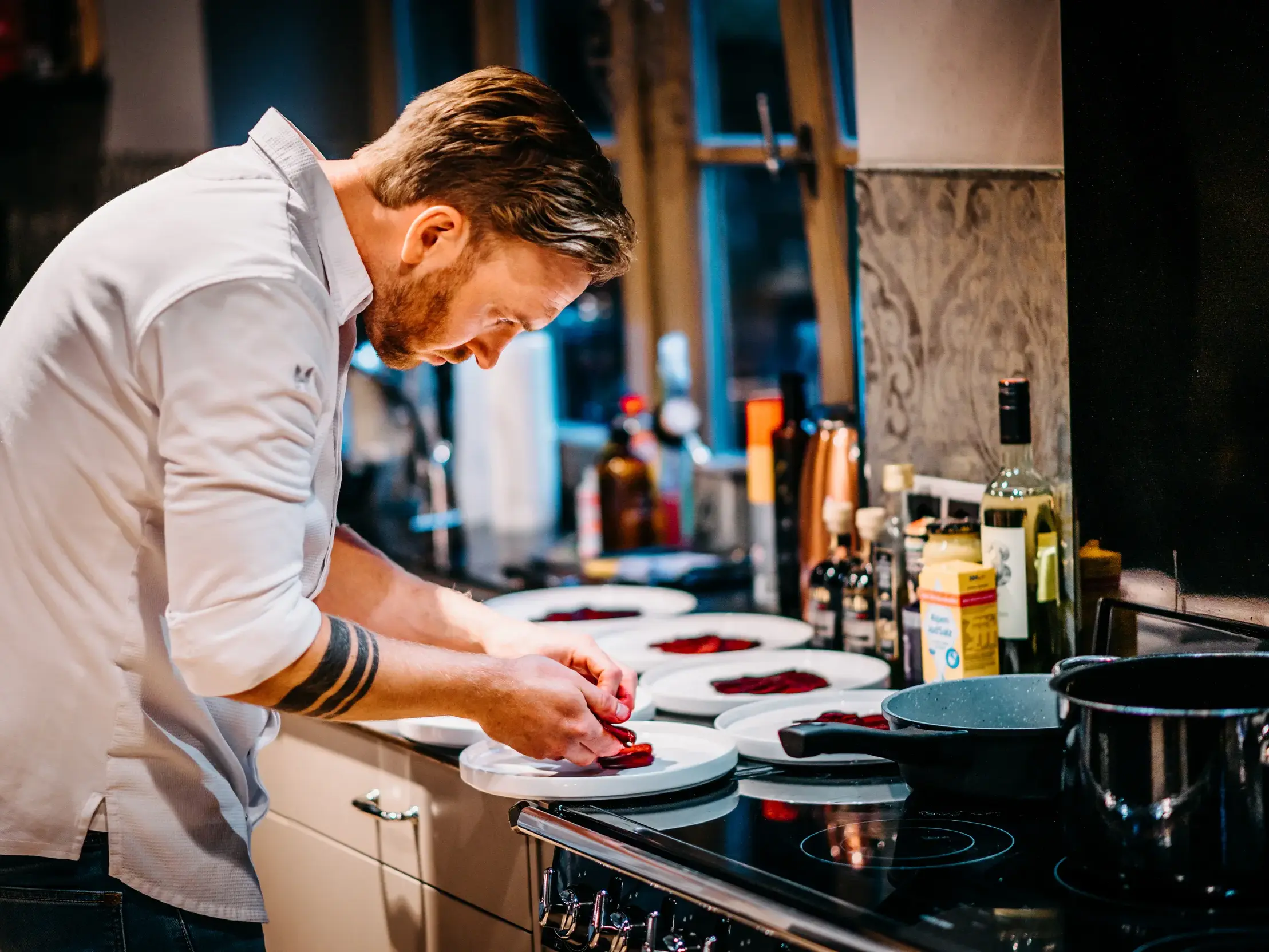 Privatkoch Sascha Zellinger richtet in der Küche des Wurzerhofs mit Sorgfalt das Abendessen für die Reisegruppe an.