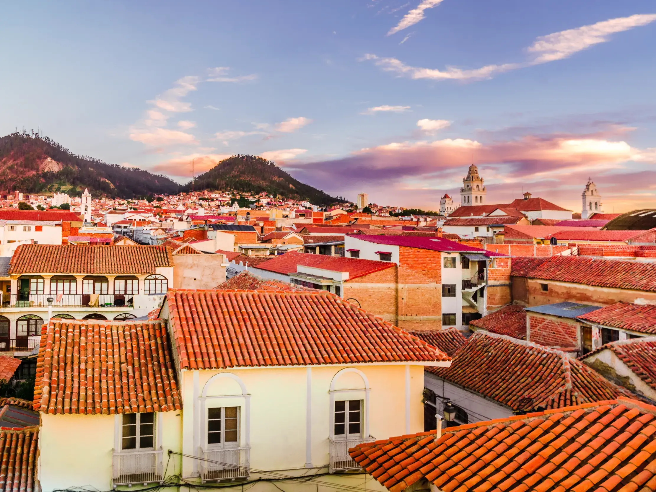 Blick über die roten Dächer der Kolonialstadt Sucre in Bolivien während einer Studiosus-Studienreise bei Sonnenuntergang.