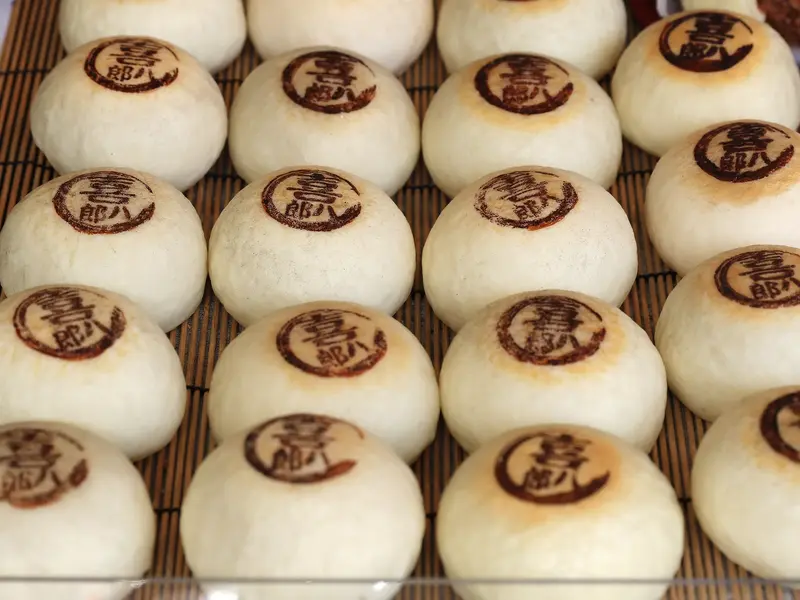Reihen von japanischen Manju-Brötchen mit Kanji-Stempel, eine Spezialität auf dem Nishiki-Delikatessenmarkt in Kyoto.